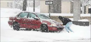  ?? TOM KELLY III — FOR DIGITAL FIRST MEDIA ?? A good samaritan pushes out a motorist whose vehicle got stuck in a snow bank on North Franklin Street in Pottstown.