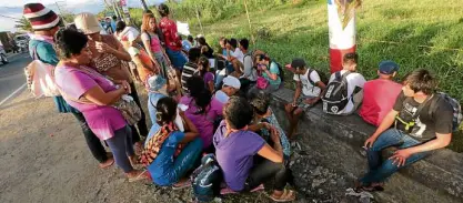  ?? —GRIG C. MONTEGRAND­E ?? WAITING FOR LOVED ONES Relatives of suspected communist rebels who were killed in a clash with soldiers in Batangas wait on the wall of a roadside ditch in front of St. Peter’s Funeral Home in Nasugbu, Batangas, where authoritie­s were conducting...