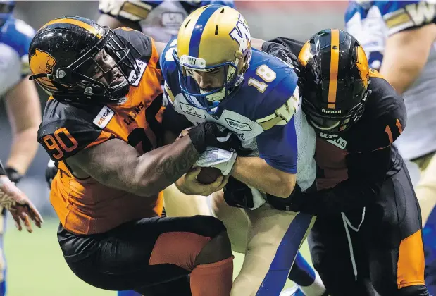  ?? — CP FILES ?? Only 15,237 fans turned out at B.C. Place to watch Winnipeg quarterbac­k Alex Ross get sacked by the Lions Odell Willis, right, and Davon Coleman in Friday’s pre-season game. It was the team’s last tune-up before the season begins at home against...