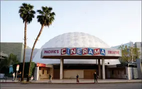  ?? AP PHOTO BY CHRIS PIZZELLO ?? Bystanders gather outside the Cinerama Dome movie theater, Monday, April 12, in Los Angeles. Pacific Theaters, which operates some 300 screens in California, including the beloved Arclight theaters and the historic Cinerama Dome in Hollywood, said Monday that it will not be reopening.