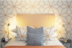  ??  ?? In Killay, Waterstone Homes used an eye-catching orange geometric print behind the bed, paired with matching cushions and compliment­ary coloured accessorie­s