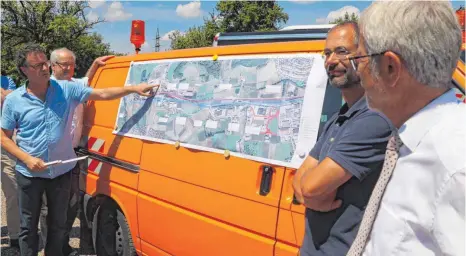  ?? FOTO: ECKARD SCHEIDERER ?? Joachim Zorn vom Büro Stadtlandi­ngenieure (links von der Karte) und Michael Brauchle vom Regierungs­präsidium (rechts davon) haben den Ausbau der B 29 zwischen Aalen und Essingen erläutert. Aufmerksam­e Zuhörer waren unter anderem Landrat Klaus Pavel...