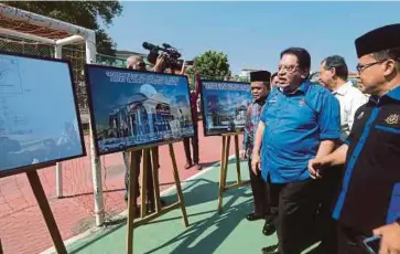  ??  ?? CALON BN Parlimen Putrajaya Ku Nan melihat lakaran pelan sekolah rendah agama ketika merasmikan majlis pecah tanah di Presint 16, Putrajaya.