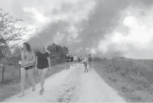  ?? SUN SENTINEL PHOTOS PHILLIP VALYS SOUTH FLORIDA ?? Onlookers leave Everglades Holiday Park as smoke billows in the background.