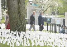  ?? ?? LEFT: Saint Francis Hospital Executive Director of Mission Integratio­n Jerry Galipeau, left, and hospital President Thomas Burke walk between fields of flags representi­ng the COVID-19 patients the hospital cared for during the pandemic.