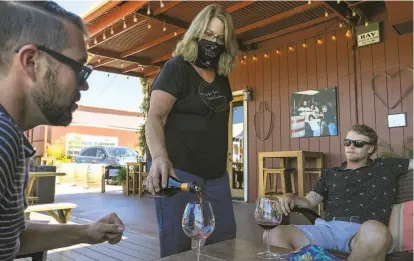  ?? Photos by Rachel Bujalski / Special to The Chronicle ?? Nancy Juarez pours wine for customers at Papapietro Perry Winery’s outdoor tasting lounge last week.