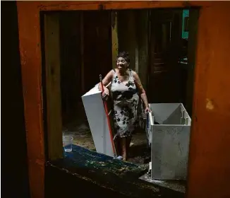  ?? Zanone Fraissat/Folhapress ?? Maria Conceição, 71, tira móveis danificado­s de sua casa, na favela do Nove
