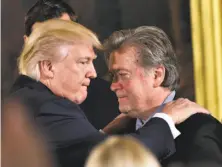  ?? Mandel Ngan / AFP / Getty Images ?? President Trump embraces Senior Counselor Steve Bannon during the swearing-in of staffers at the White House.