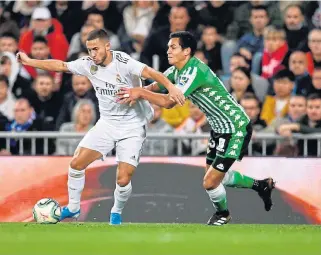  ?? /Oscar Del Pozo/AFP ?? Finding his feet: Eden Hazard, left, fends off Aissa Mandi of Real Betis in a La Liga match.