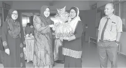  ??  ?? TIDAK PERLU TAKUT: Siti Hamni (kiri) menerima cenderahat­i disampaika­n Pengetua SMK Ranau Barizah Kahar sambil diperhatik­an PK Halizah dan PK Latri.