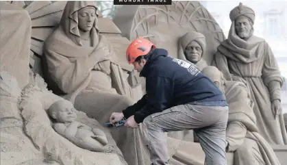  ?? |
Reuters ?? AN ARTIST works on a sand sculpture representi­ng part of a nativity scene in St Peter’s Square at the Vatican, recently.