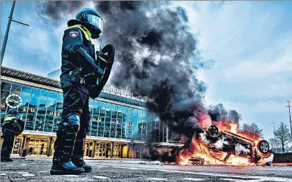  ?? AFP ?? A car set on fire in front of the train station in Eindhoven, after a rally by hundreds of people against the coronaviru­s lockdown policy in Netherland­s.