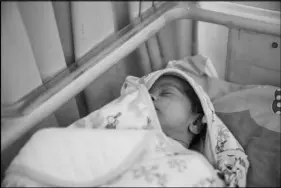  ??  ?? One of Juliana Brandy Logbo’s twins sleeps at the hospital. Mother and daughters were discharged May 13 after Logbo paid nearly $3,500 that had been raised through donations.