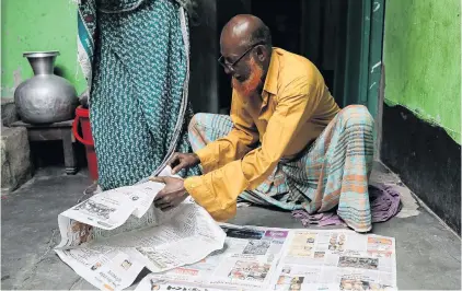  ?? PHOTO: REUTERS ?? Sad search . . . Hafiz Mia flips through the newspapers for news about his son Riazul Islam, an alleged drug dealer who was killed by police in Tongi, Gazipur.