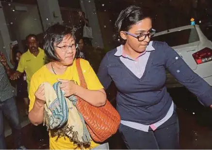  ??  ?? Bersih 2.0 chairman Maria Chin Abdullah being escorted by a policewoma­n outside the Bersih office.