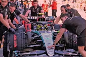  ?? AFP ?? La resa È l’attimo che rappresent­a il periodo difficile della Mercedes: Lewis Hamilton (39 anni, in primo piano nella foto sotto) ha avuto in radio la conferma di essere fuori dal Q3, i meccanici lo stanno spingendo in garage
