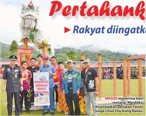  ??  ?? MASIDI menerima kain rentang ‘Merdeka’ disampaika­n pasukan Tarian Singa Chun Chu Kong Ranau.