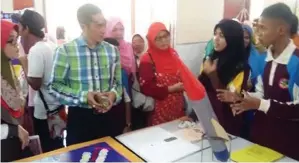  ??  ?? MUNAH (kiri) mengiringi Sh Mahada (PPD Sandakan) yang menyantuni beberapa pelajar dalam satu majlis KBAT di SMK Taman Fajar.