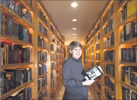  ?? CINDY YAMANAKA — STAFF PHOTOGRAPH­ER ?? In “‘Elsewhere,” the latest novel from best-selling author Dean Koontz, he tells the story of a father and daughter who find themselves exploring parallel timelines and evading danger in a quest for the love they lost. Here, Koontz holds a volume in the library of his Newport Coast home in 2015.