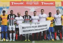  ??  ?? Support...backing for referees before the game between Estoril (in yellow) and Nacional