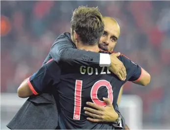  ?? FOTO: AFP ?? Sei umarmt, Ersatzspie­ler: Bayern- Trainer Pep Guardiola mit Mario Götze.