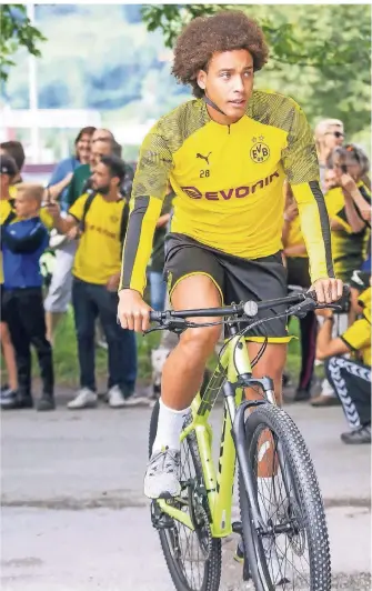  ?? FOTO: IMAGO IMAGES ?? Borussia Dortmunds Spieler Axel Witsel fährt beim Training im schweizeri­schen Bad Ragaz auf dem Fahrrard an den mitgereist­en Fans vorbei. Die machen Fotos von den BVB-Spielern.