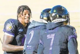  ?? KEVIN RICHARDSON/BALTIMORE SUN ?? Ravens QB Lamar Jackson, left, talks with quarterbac­ks Tyler Huntley and Kenji Bahar at practice in Owings Mills.