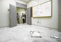  ?? Jon Shapley / Staff photograph­er ?? From left, Sergio Leal, an engineerin­g contractor, Judy Allton, a curator at Johnson Space Center, and Osvaldo Salinas, an intern, peer into the room where astronauts were quarantine­d in 1969.