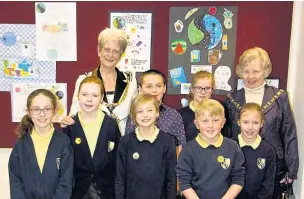  ??  ?? ●● Puss Bank school pupils with some of the Fairtrade posters, Macclesfie­ld Mayor Coun Liz Durham and East Cheshire Mayor Coun Hilda Gaddum
