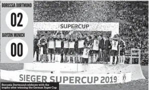  ??  ?? Borussia Dortmund celebrate with the trophy after winning the German Super Cup