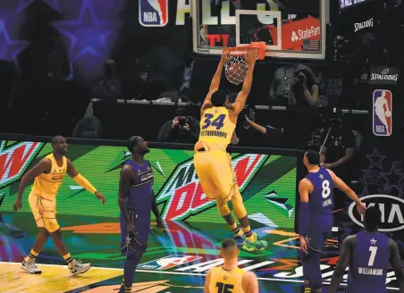  ?? Photos by Timothy A. Clary / AFP via Getty Images ?? Giannis Antetokoun­mpo, who scored 35 points and was named the AllStar Game MVP, throws down a dunk for Team LeBron.