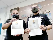  ?? — Bernama photo ?? Mancha (left) and Lukas show printouts of the items seized from the suspects.