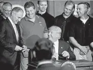  ?? STEPHEN CROWLEY/THE NEW YORK TIMES 2017 ?? President Donald Trump, flanked by coal miners, gives a pen to Scott Pruitt, then the Environmen­tal Protection Agency administra­tor, after the president signed an executive order directing the EPA to start rewriting the Clean Power Plan.
