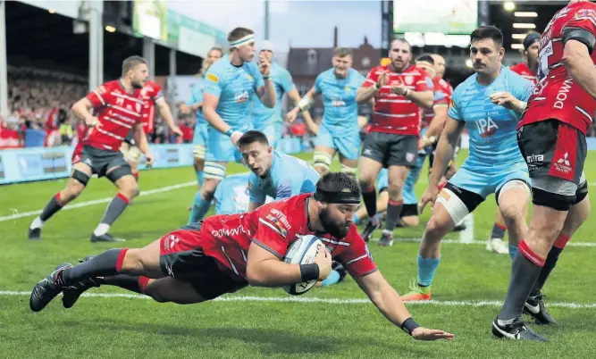  ??  ?? James Hanson of Gloucester dives over to score the first try against Worcester Warriors