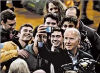 ??  ?? Presidenti­al candidate and former Vice President Joe Biden takes selfies with supporters during a campaign event at Roosevelt Creative Corridor Business Academy leading up to the Iowa caucuses.