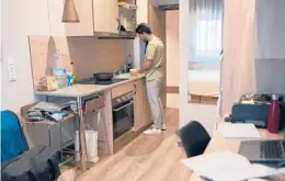  ?? LAURA LEON/THE NEW YORK TIMES 2021 ?? Brian Dervishi, an Italian student, prepares a meal in the kitchen of housing he rents in the Livensa Living student dormitory in Malaga, Spain.