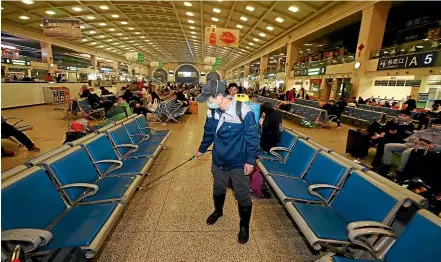  ?? AP ?? A worker sprays disinfecta­nt at a train station in Wuhan in southern China’s Hubei province.