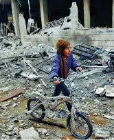  ??  ?? La bicicletta Un bambino nella città sotto assedio di Hamouria, nella regione di Ghouta, alle porte di Damasco (Bassam Khabieh/Reuters)