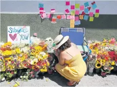  ?? AP ?? A makeshift memorial of flowers, candles and notes grows on the sidewalk outside the Los Feliz Trader Joe’s store in Los Angeles.