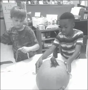  ??  ?? Measuremen­t: In Connie Hammett’s science class, Junction City Elementary students Aidan Duggar and Jakobe Benton measure their class pumpkin.