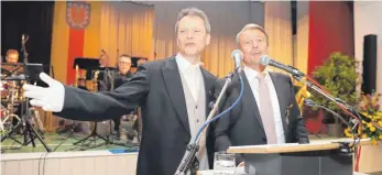  ?? FOTO: ALEXANDER TUTSCHNER ?? Ortsvorste­her Martin Frank (links) kommt beim Abschiedsa­bend von Jürgen Beisswenge­r als „Bote vom Gemeindera­t“in Hennensupp­en-Manier ans Mikrofon, am Ende der humorvolle­n Laudatio auf den scheidende­n Schultes wird gemeinsam gesungen: Aus „Liebe ohne...