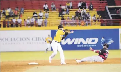  ??  ?? Ronny Rodríguez, de las Águilas, fuerza en la segunda base a Danny Richar, de los Leones del Escogido y lanza a la primera base para tratar de completar una doble matanza.