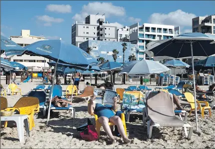  ?? ASSOCIATED PRESS ?? DAN BALILTY Just a few people enjoy the beach on the Mediterran­ean Sea at Tel Aviv this past week. This was supposed to be a record year for tourism, but people around the world have canceled their visits.