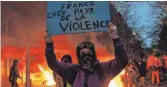  ?? FOTO: ANNE-CHRISTINE POUJOULAT/AFP ?? Demonstran­ten in Paris setzten auch Autos in Brand.