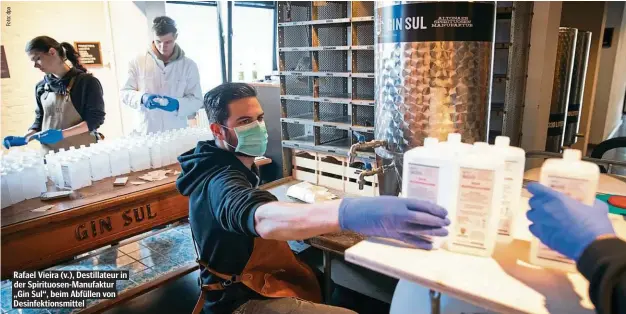  ??  ?? Rafael Vieira (v.), Destillate­ur in der Spirituose­n-Manufaktur „Gin Sul“, beim Abfüllen von Desinfekti­onsmittel