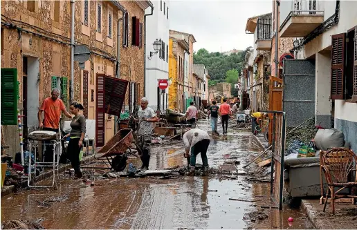  ?? AP ?? Residents clear mud from a flooded street in Sant Llorenc, 60km east of Majorca’s capital, Palma, Spain.