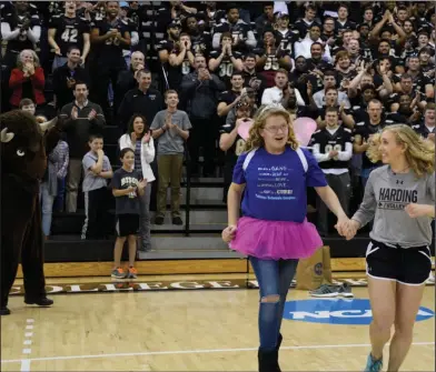  ??  ?? Wish: Alissa Carter and Bison volleyball player Taylor Lake run across the court at the Make-A-Wish reveal celebratio­n in the Rhodes-Reaves Field House.