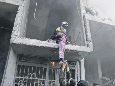  ??  ?? A young girl is rescued from a building hit by airstrikes and shelling by Syrian government forces in Ghouta.