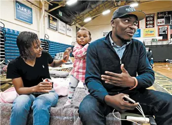  ?? ELISE AMENDOLA/AP PHOTOS ?? Prince Pombo, right, of the Congo, seen with his wife, left, and daughter, are living in an emergency shelter in Maine.