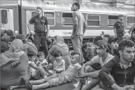  ?? MAURICIO LIMA/THE NEW YORK TIMES ?? Refugees, mainly from Syria and Afghanista­n, crowd a platform as they wait for a train in Budapest, Hungary. Chancellor Angela Merkel of Germany and President Vladimir Putin of Russia, met recently to attempt to find common ground on key internatio­nal issues, including the Syrian civil war.